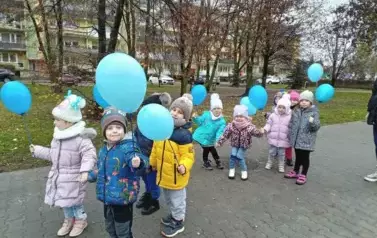 dzieci na spacerze z niebieskimi balonami