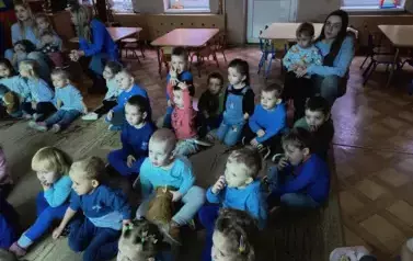 dzieci ubrane na niebiesko oglądają film edukacyjny