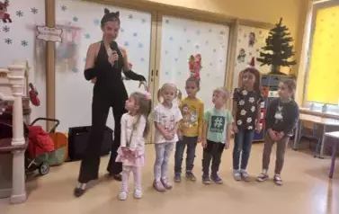 kilkoro dzieci stoi na  środku z panią przebraną za kota