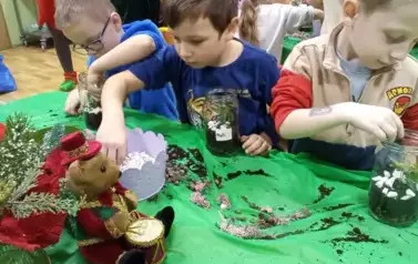 dzieci sadzą roślinkę w słoiku