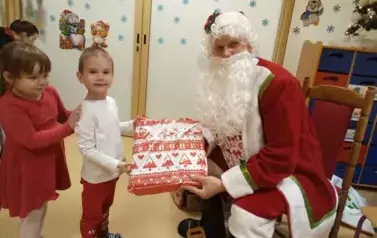 Mikołaj rozdaje dzieciom prezenty