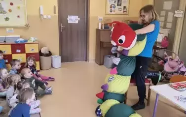pani porwadząca pokazuje dzieciom pluszową gąsienicę