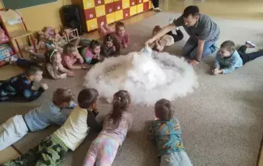 dzieci obserwują chmurę z suchego lodu