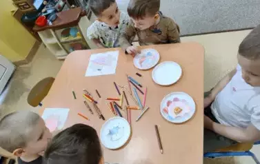 dzieci kolorują kwiaty z papieru
