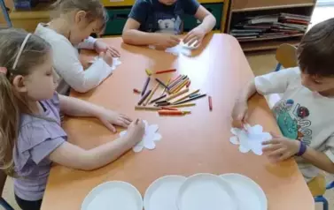 dzieci składają kwiaty z papieru