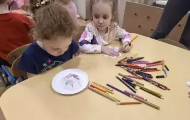 dzieci obserwują kwiat z papaieru