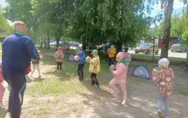 dzieci ćwiczą z piłkami w ogrodzie przedszkolnym