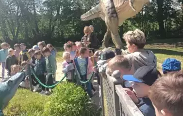 dzieci ogladają figury dinozaur&oacute;w