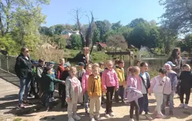 dzieci zwiedzają park dinozaur&oacute;w