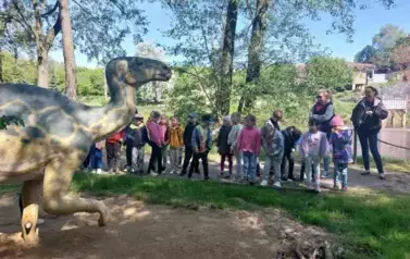 dzieci zwiedzają park dinozaur&oacute;w
