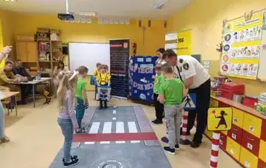dzieci prowadzą symulację ruchu drogowego