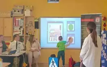 chłopiec rozwiązuje zadanie na tablicy multimedialnej