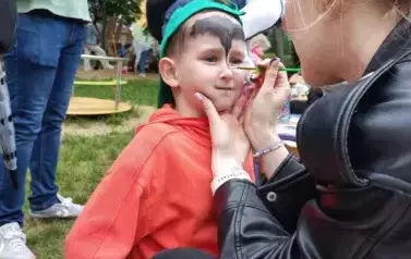 pani maluje chłopcu buzię