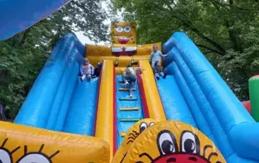 dzieci bawią się na dmuchanej zjeżdżalni