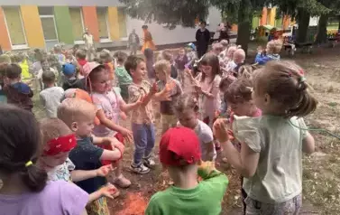 dzieci rozsypują kolorowe proszki holi
