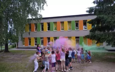 dzieci rozsypują kolorowe proszki holi