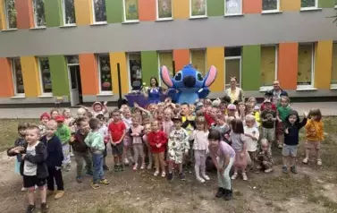 dzieci pozują do zdjęcia z maskotką Stitcha