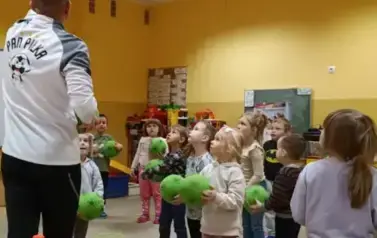 dzieci stoją trzymając piłki