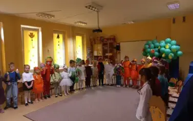 dzieci przebrane za warzywa stoją na sali