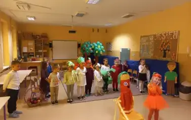 dzieci przebrane za warzywa stoją na sali