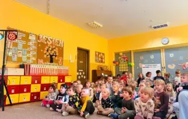 dzieci siedzą na dywanie