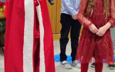 chłopiec przebrany za Mikołaja z dziewczynką m&oacute;wią wiersz