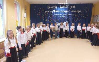 dzieci ustawione w p&oacute;łkolu w uroczystych galowych strojach