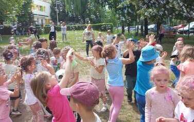 dzieci bawią się w kolorowych proszkach i bańkach mydlanych