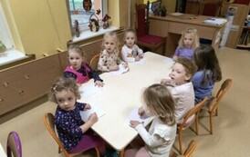 dzieci zakrywają szklanymi naczyniami świeczkę w miseczce