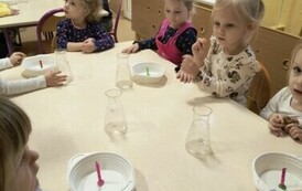 dzieci obserwują palącą się świeczkę