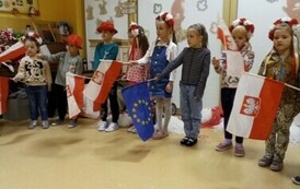 starszaki w czapkach biało - czerwonych z flagami Polski