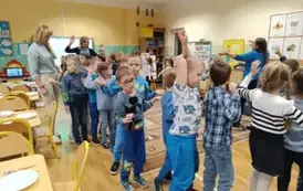 dzieci ubrane na niebiesko ida po kole