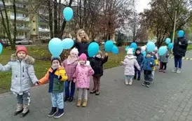 dzieci spacerują z niebieskimi balonami