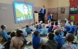 dzieci oglądają prezentację wyświetlaną przez panią psycholog