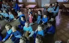 dzieci ubrane na niebiesko oglądają film edukacyjny