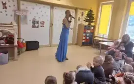 pani ubrana w niebieską suknię śpiewa piosenkę