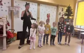 kilkoro dzieci stoi na  środku z panią przebraną za kota