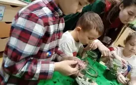 dzieci wkładają kamyczki do słoik&oacute;w