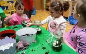dzieci sypią ziemię do słoik&oacute;w
