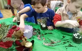 dzieci sadzą roślinkę w słoiku