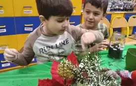 chłopcy wkładają ozdoby do słoika