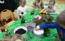 dzieci sypią ziemię do słoik&oacute;w