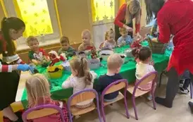 dzieci siedzą przy stolikach