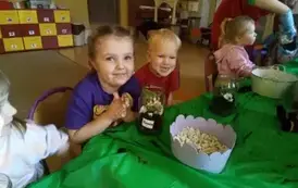 dzieci siedzą przy stolikach