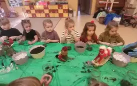 dzieci siedzą przy stolikach