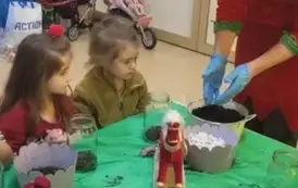 dzieci obserwują panią sypiącą ziemię