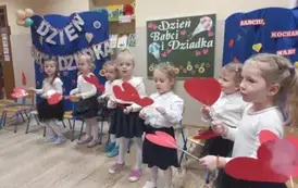 dzieci trzymają serduszka dla dziadk&oacute;w