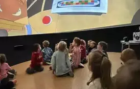 dzieci oglądają film w mobilnym planetarium