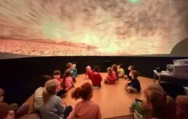 dzieci oglądają film w mobilnym planetarium