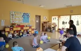 dzieci siedzą w kole z prowadzącym